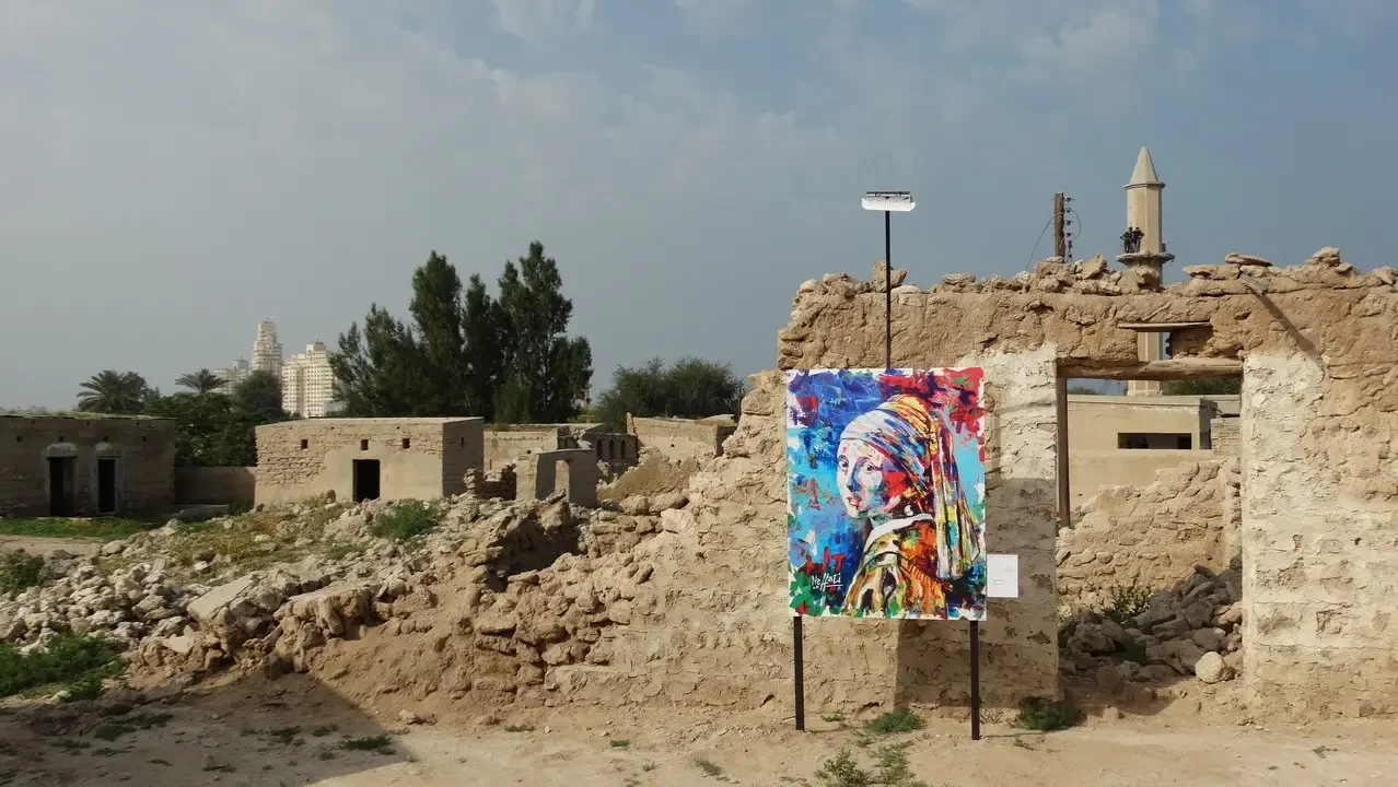 Resti di pietra con un murale colorato in un paesaggio arido.