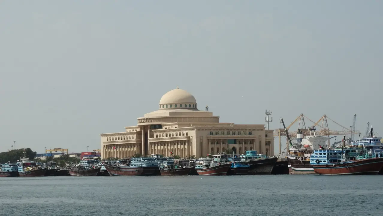 Un grande edificio con cupola si affaccia sul porto in Oman o negli Emirati Arabi Uniti. Un grande edificio con cupola si affaccia sul porto in Oman o negli Emirati Arabi Uniti.