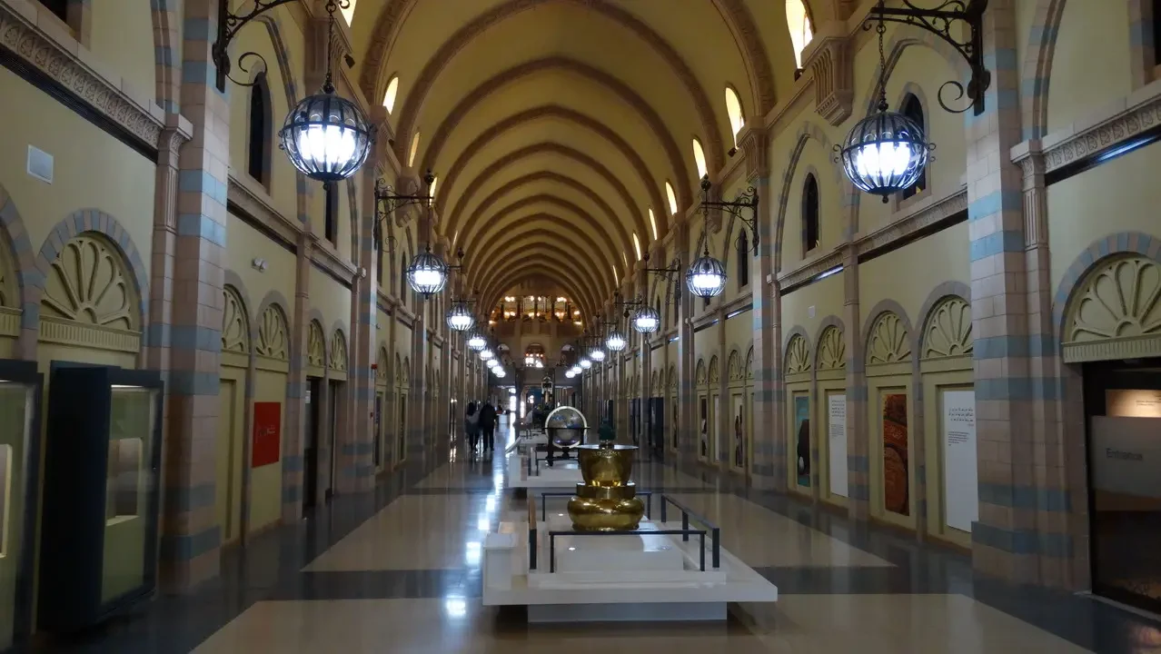 Corridoio interno di un museo storico con soffitti a volta decorati.