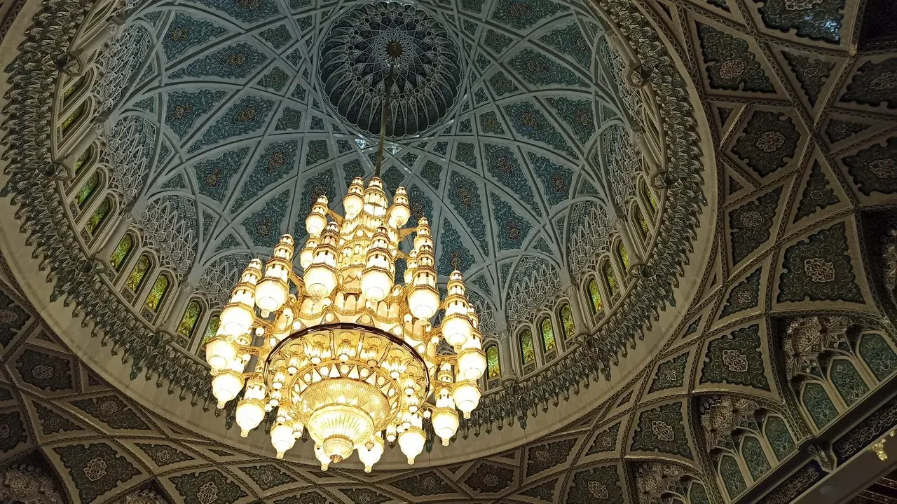 Vista del soffitto ornato e di un grande lampadario in una sala imponente.