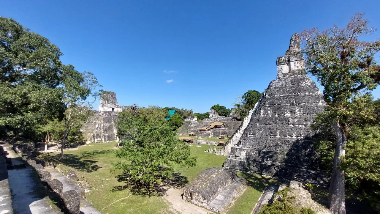 Le piramidi della città di Tikal sotto un cielo azzurro.