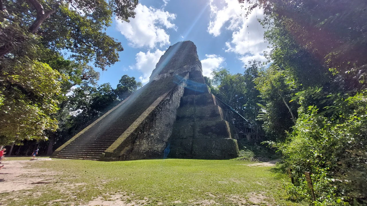 Le scale a gradoni di una piramide antica si estendono sotto un cielo azzurro in America Centrale.