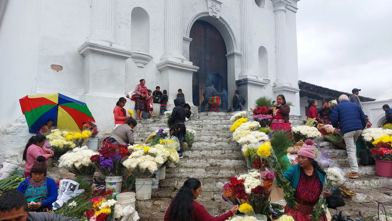 Una vista esterna della chiesa di Chichicastenango con persone che partecipano a un evento.