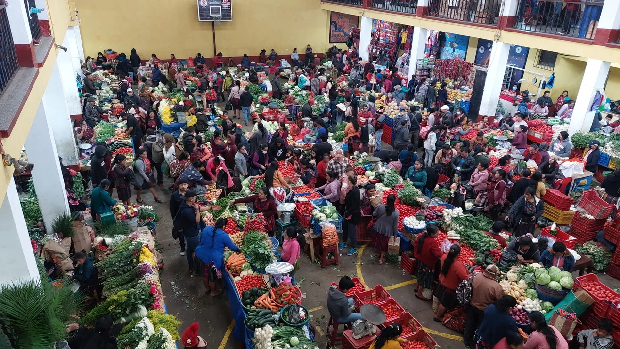 Gente che naviga tra bancarelle di un vivace mercato.