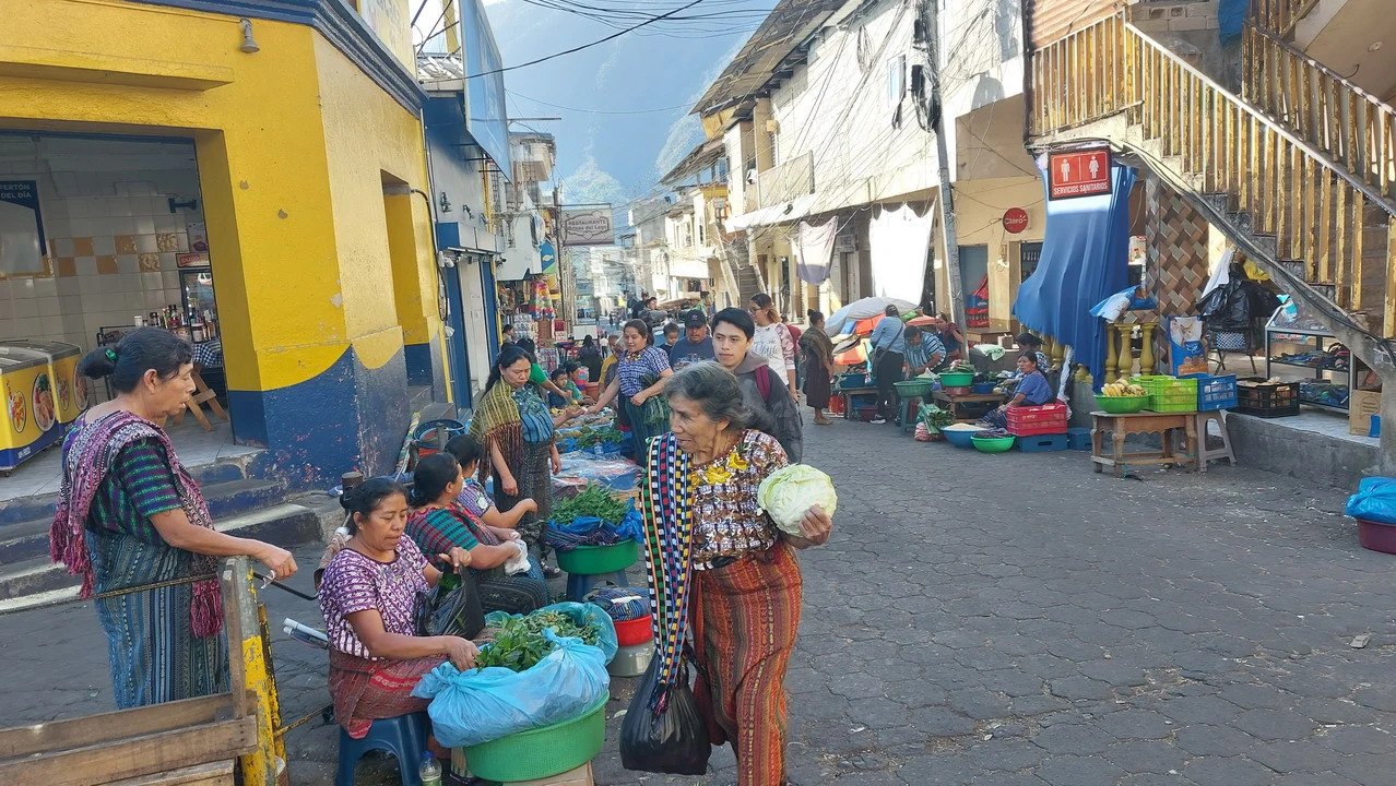 Mercato all'aperto con venditori e merci lungo una strada in America Centrale.