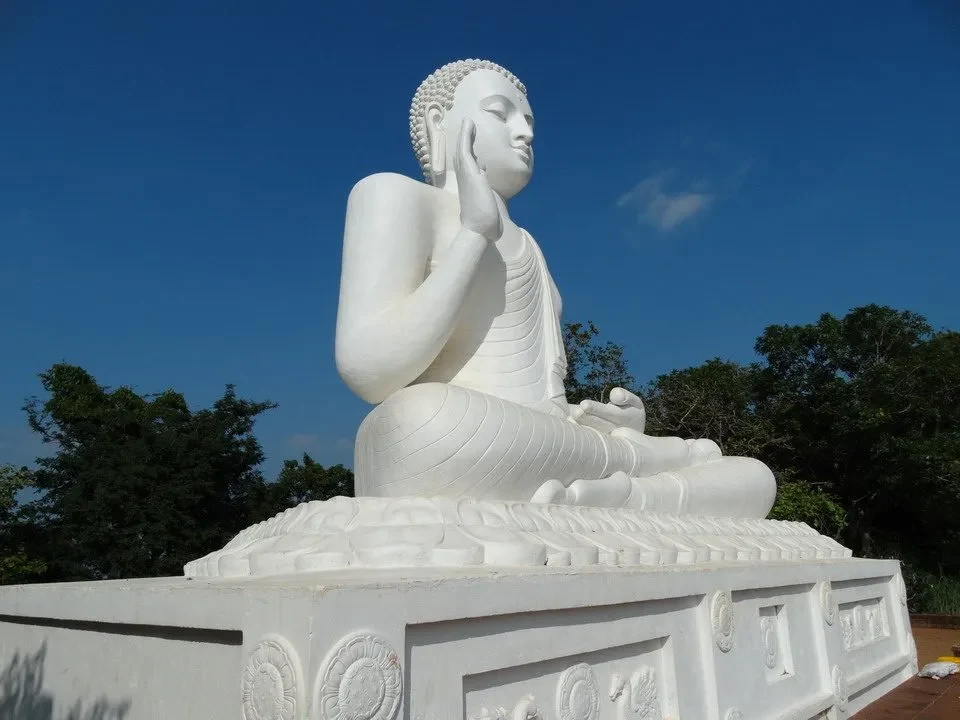Statua di Buddha seduto in meditazione all'aperto.