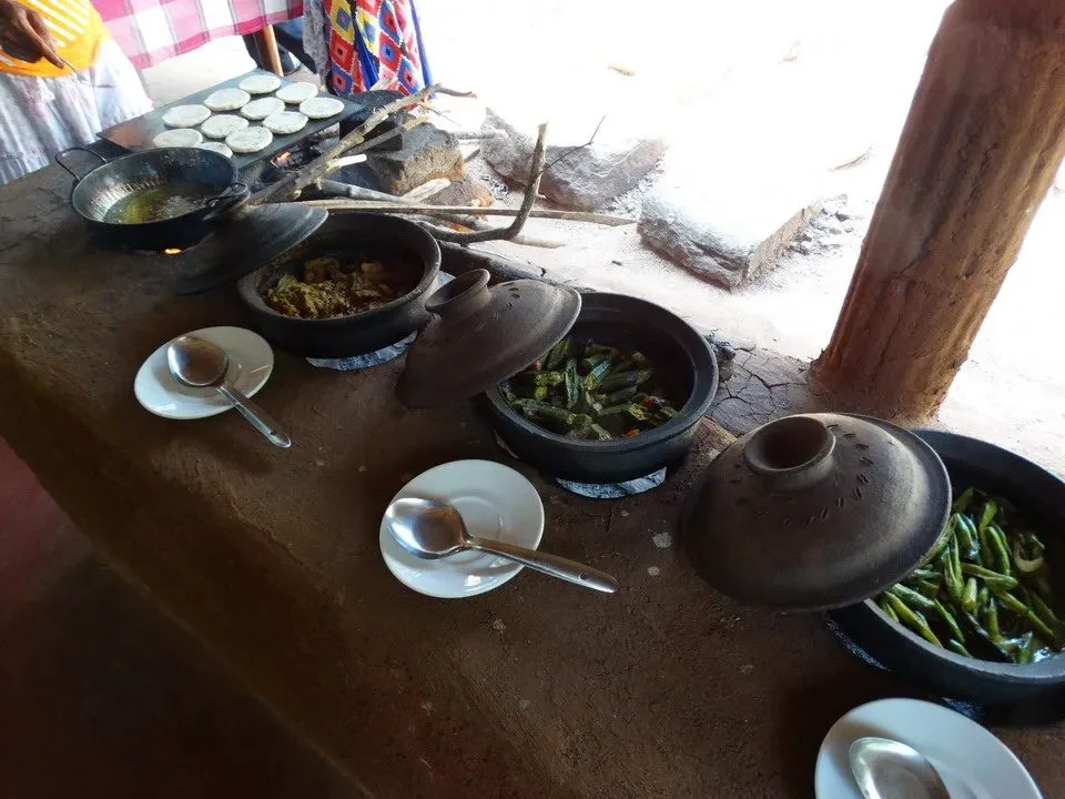 Un pasto rustico all'aperto in Sri Lanka con diversi piatti in terracotta.