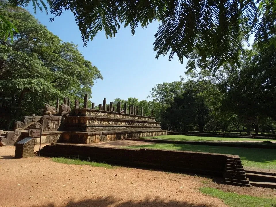 Le rovine della cittadella di Polonnaruwa in Sri Lanka sono visibili attraverso le foglie degli alberi.