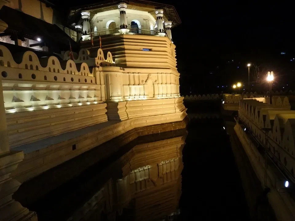 Vista notturna del tempio Tooth a Kandy, riflesso sull'acqua.