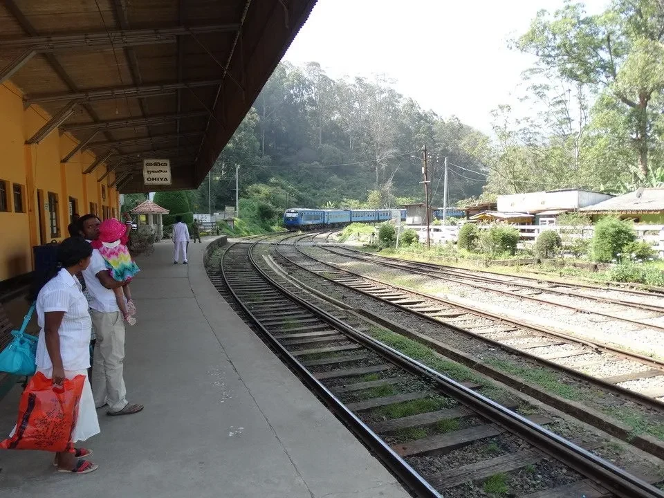 Una stazione ferroviaria in Sri Lanka con binari e treni in lontananza.