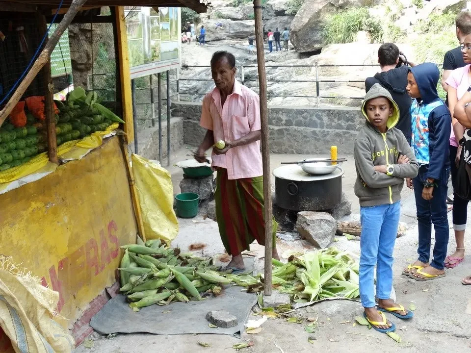 Un uomo vende cibo di strada su una strada in Sri Lanka.