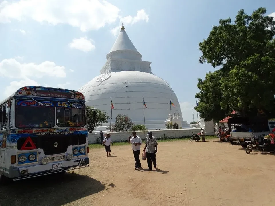 Vista panoramica del tempio bianco di Dagoba a Sri Lanka con persone in primo piano.