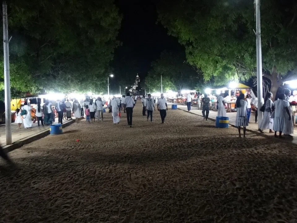 Un gruppo di persone è riunito all'aperto in un'area aperta di notte.