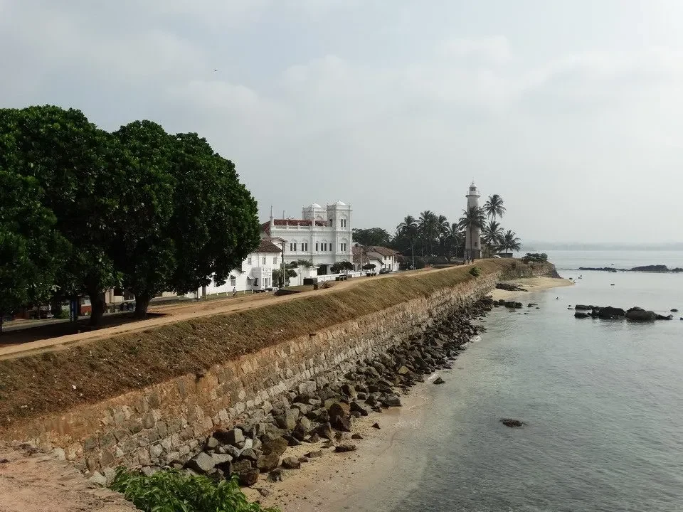 Vista panoramica di una struttura bianca lungo la costa con vegetazione e scogliere.