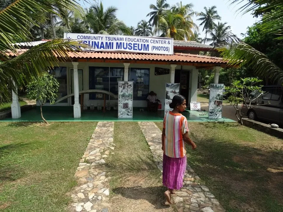 Una persona cammina davanti al museo della comunità di Sunami a Hikkaduwa, Sri Lanka.