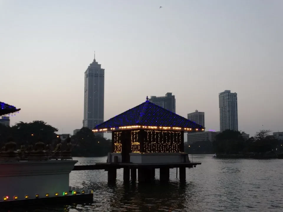 Spiaggia serale con edifici moderni riflessi sull'acqua.