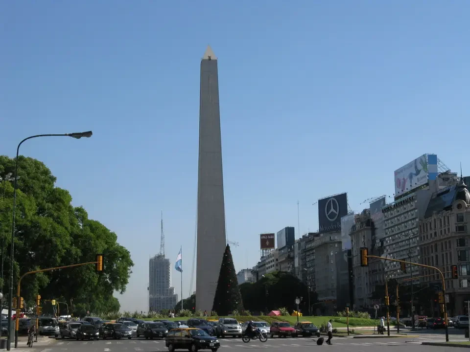 Un'inquadratura di una città con un obelisco centrale sotto un cielo limpido.