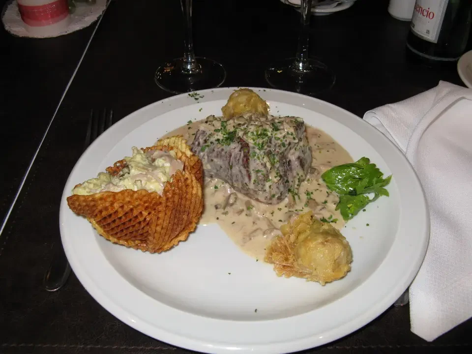 Un piatto di carne con contorno viene servito in un ristorante.