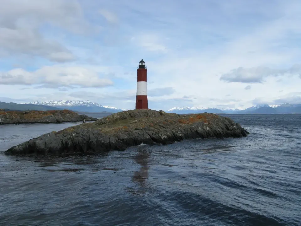 Faro rosso e bianco emerge da una scogliera rocciosa in Patagonia.