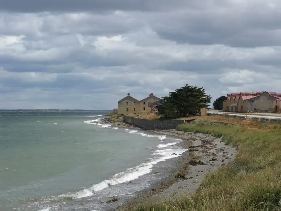 Una vista costiera con edifici in pietra sotto un cielo nuvoloso in Patagonia.