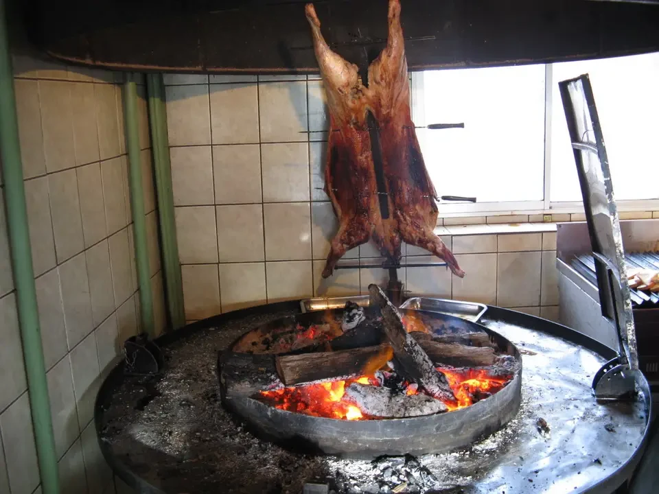 Grigliata di carne cotta su un fuoco all'aperto in una cucina rustica.