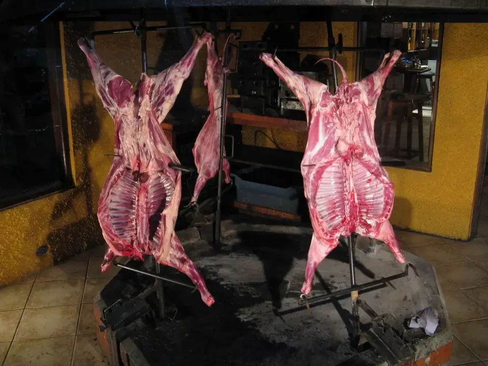 Macellati di animali esposti su una griglia in un ambiente rustico.