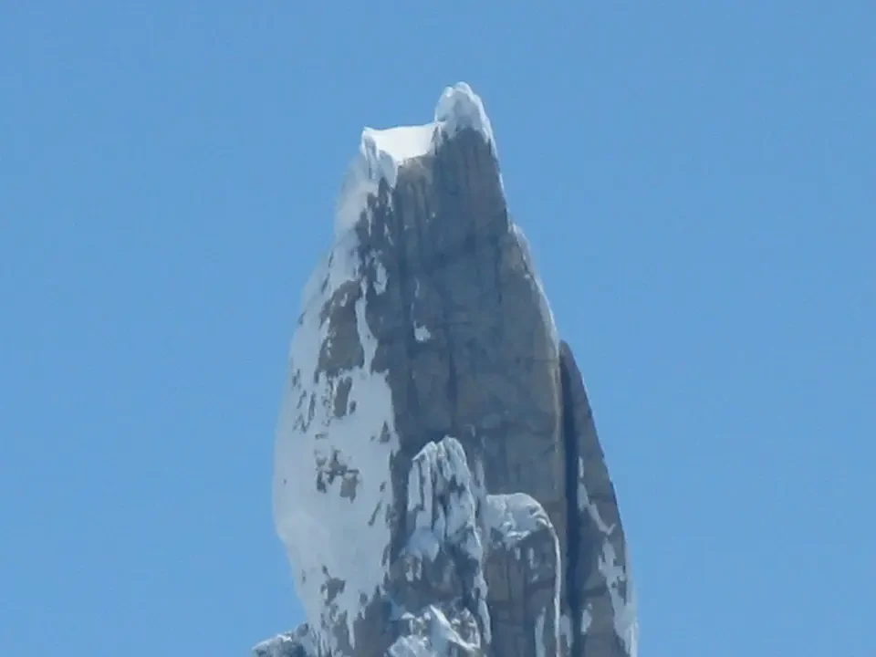 La vetta di una montagna innevata domina il cielo azzurro della Patagonia.