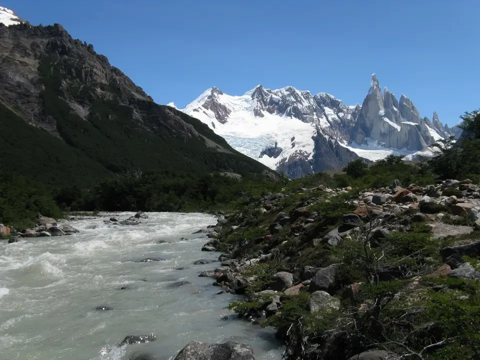 Un fiume scorre tra montagne innevate in Patagonia.