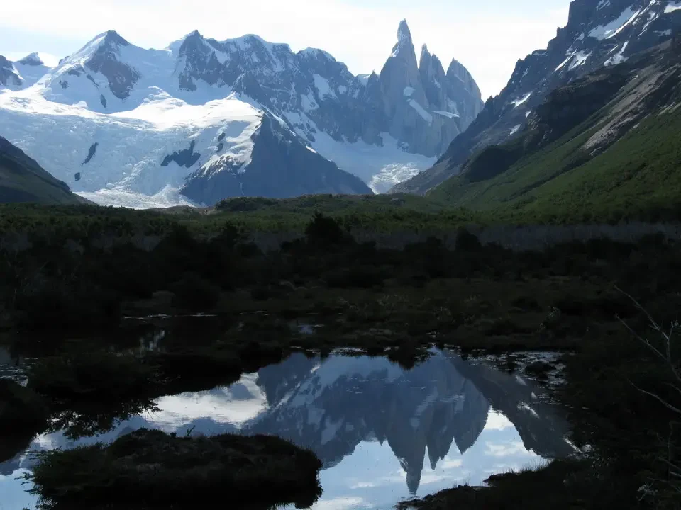 Montagne innevate riflesse sull'acqua in una valle patagonica.
