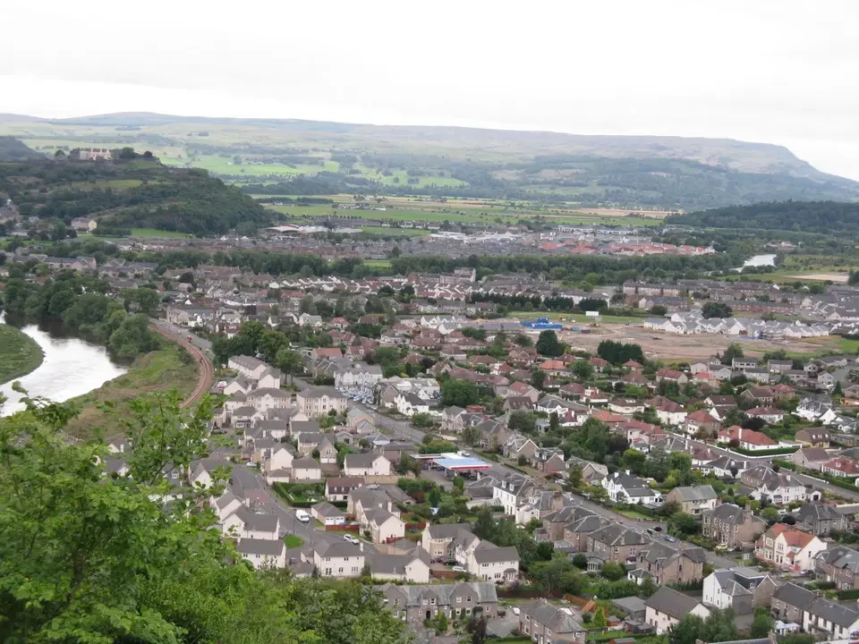 Paesaggio urbano e rurale della Scozia con una valle fluviale in primo piano.
