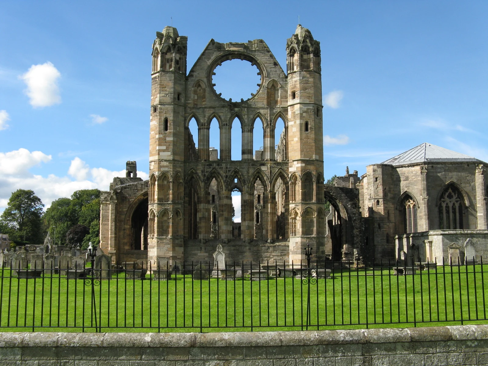 Resti della cathedrale di Elgin in Scozia visibili da un prato verde.