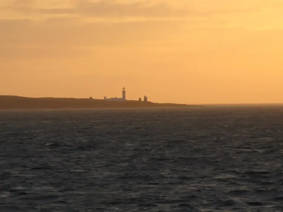 Faro isolato sulla costa scozzese al tramonto.