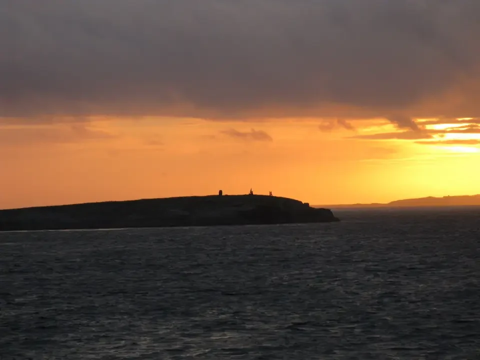 Paesaggio marino con terraferma all'orizzonte al tramonto in Scozia.