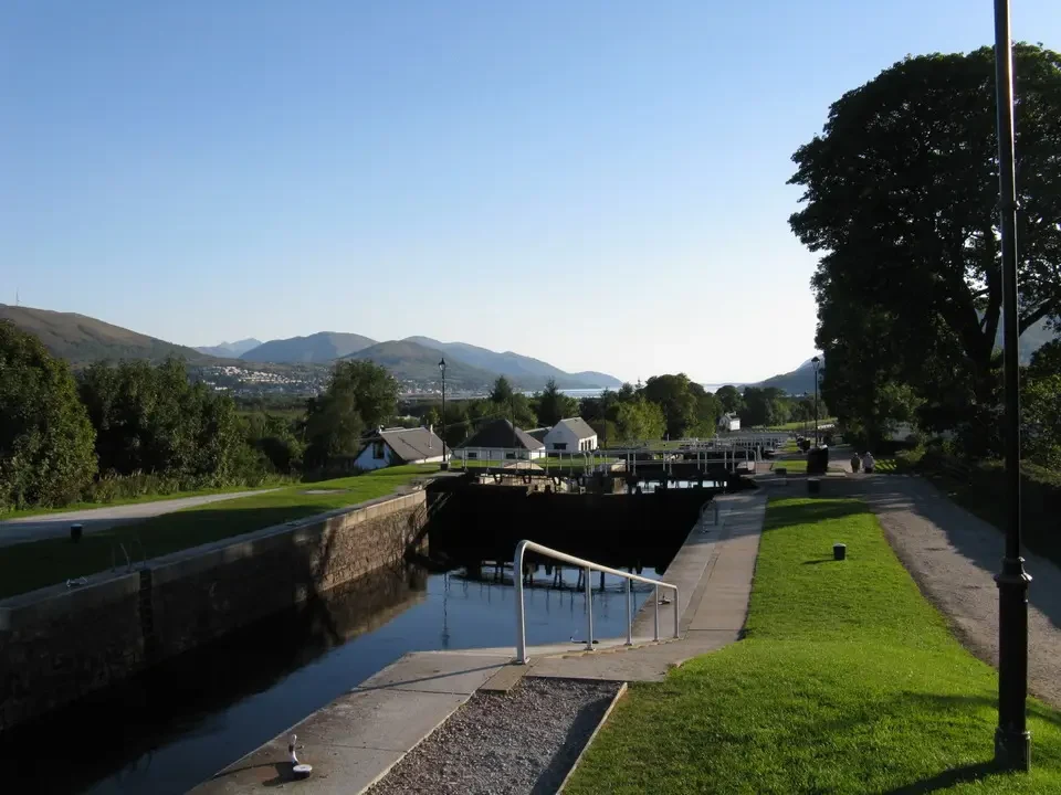 Una vista panoramica di un canale e delle colline in Scozia con una struttura in pietra.