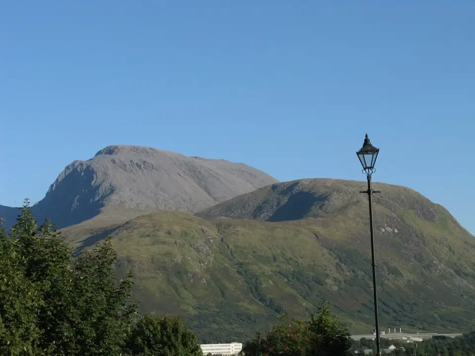 Paesaggio montano scozzese sotto un cielo azzurro.
