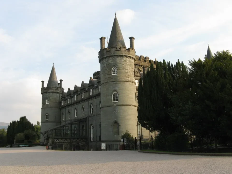 Castello di Inveraray in Scozia con mura imponenti e alberi circostanti.