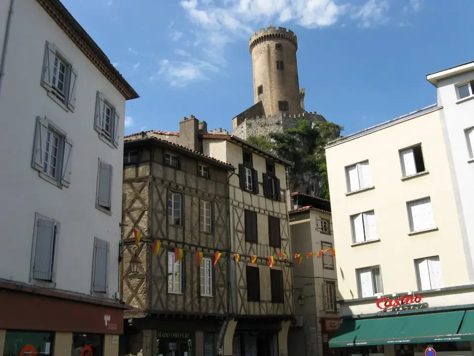 Vista panoramica di un borgo medievale con una torre in pietra in primo piano.