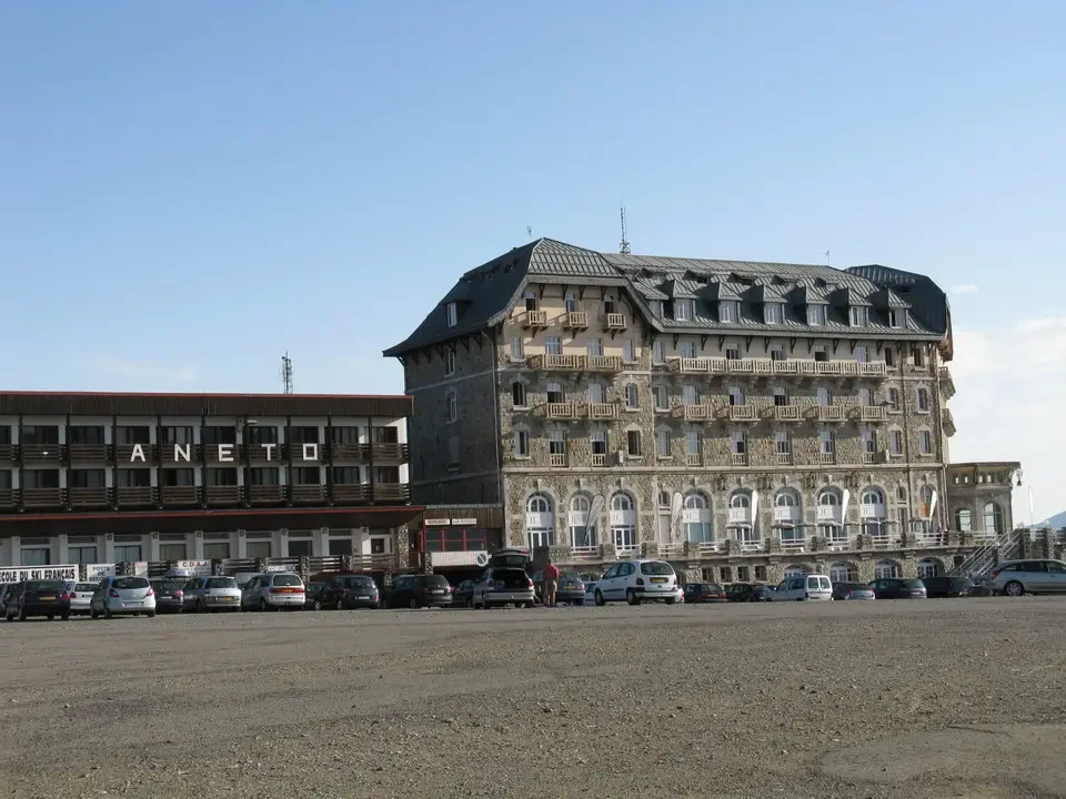 Un grande edificio storico in pietra con un ampio cortile antistante.