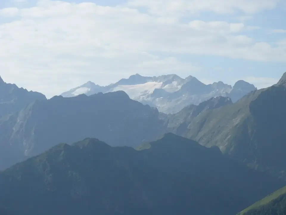 Paesaggio montano alpino con cime innevate e creste rocciose.