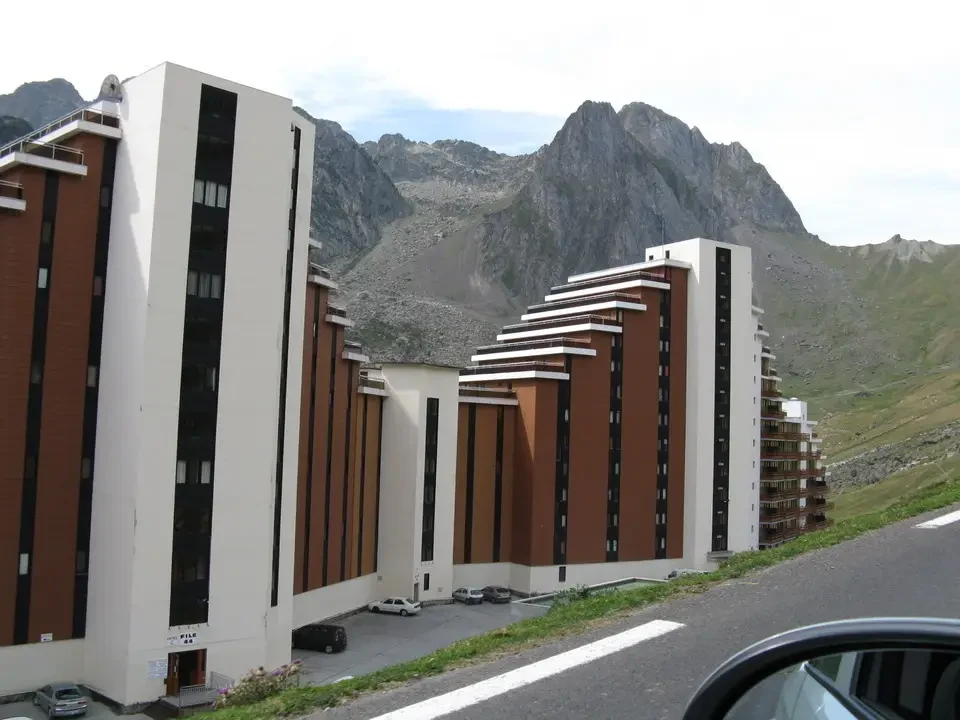 Edificio residenziale con facciata marrone e bianca in un paesaggio montano.