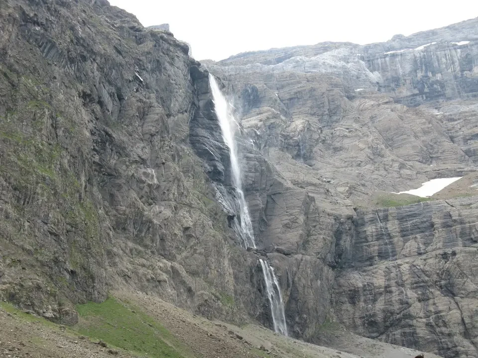 Una cascata scende lungo una ripida parete rocciosa nei Pirenei.