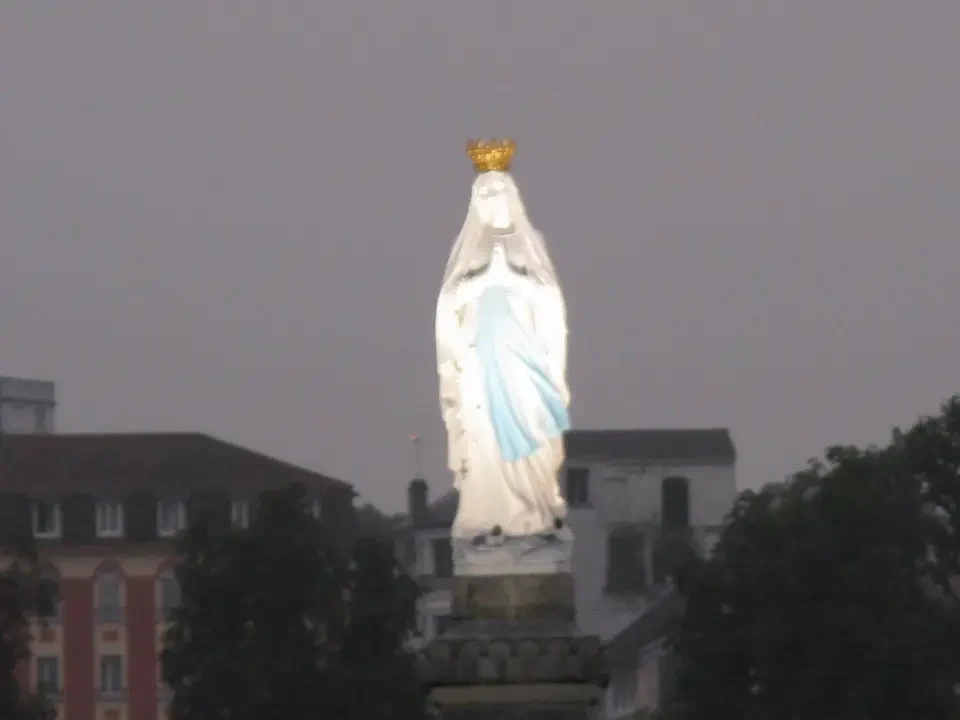 Statua della Vergine Maria in un contesto urbano.