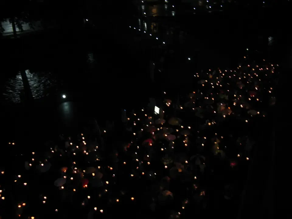 Luci soffuse riflettono sull'acqua in una scena notturna suggestiva.