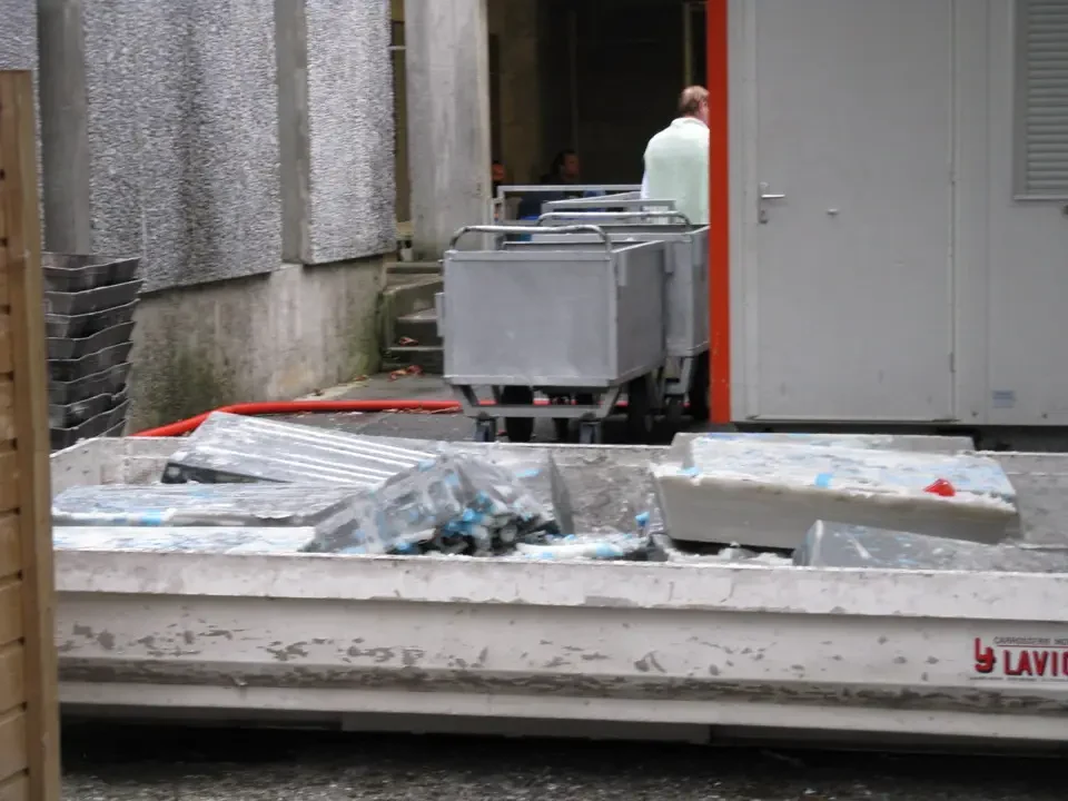 Un camion trasporta materiali su una strada umida.
