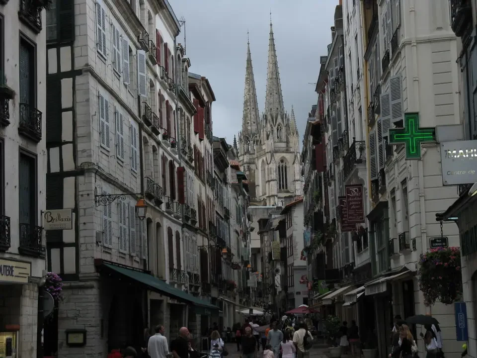 Una scena di strada in una città storica con edifici alti e guglie.