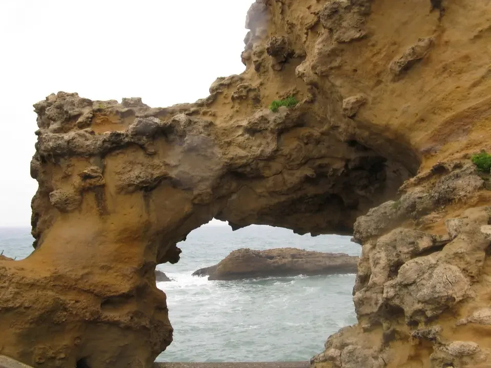 Arco roccioso sulla costa dei Pirenei con il mare in primo piano.