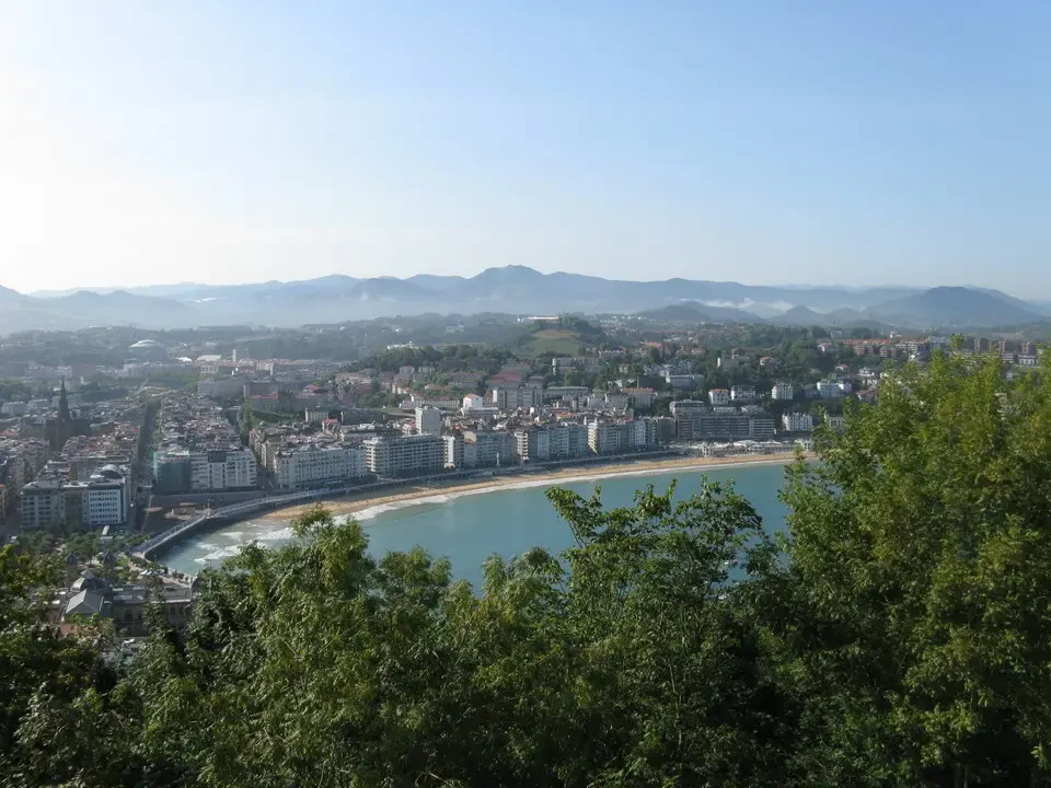 Panorama di una città costiera con vista sul mare e le montagne circostanti.
