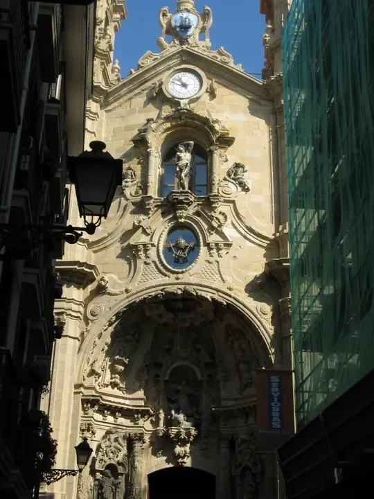 Facciata di un edificio storico in stile barocco con una finestra e un orologio sopra l'ingresso.