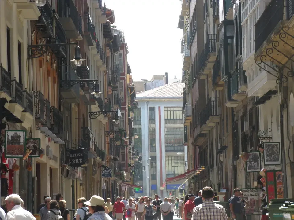 Una vivace strada storica fiancheggiata da edifici tradizionali e piena di pedoni.