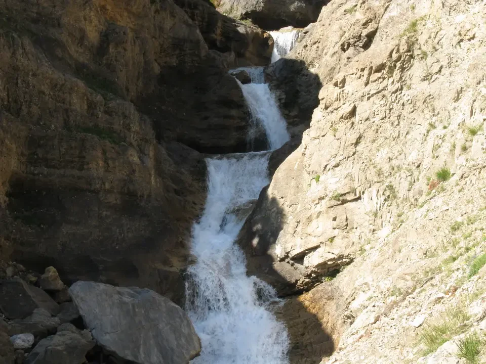 Cascata nelle valli dei Pirenei con acqua che scorre tra le rocce.